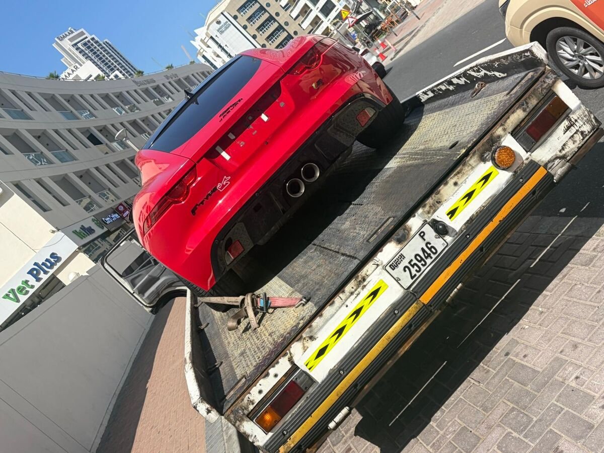 Red Jaguar on truck Dubai street