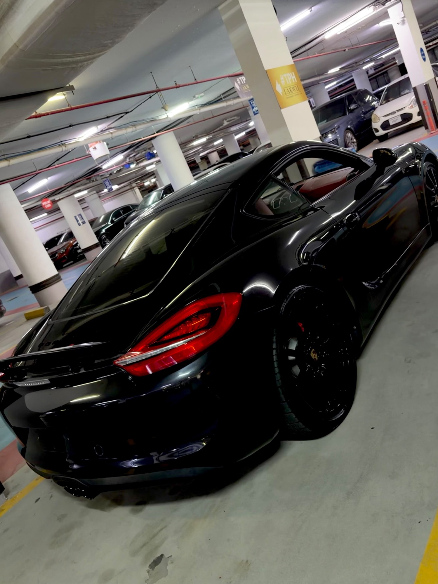 Porsche Cayman GTS black, rear side angle