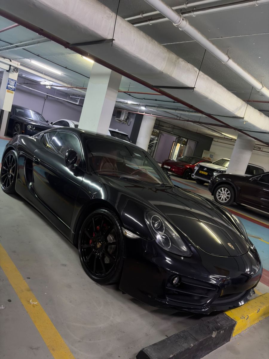 Porsche Cayman GTS black, front three-quarter angle