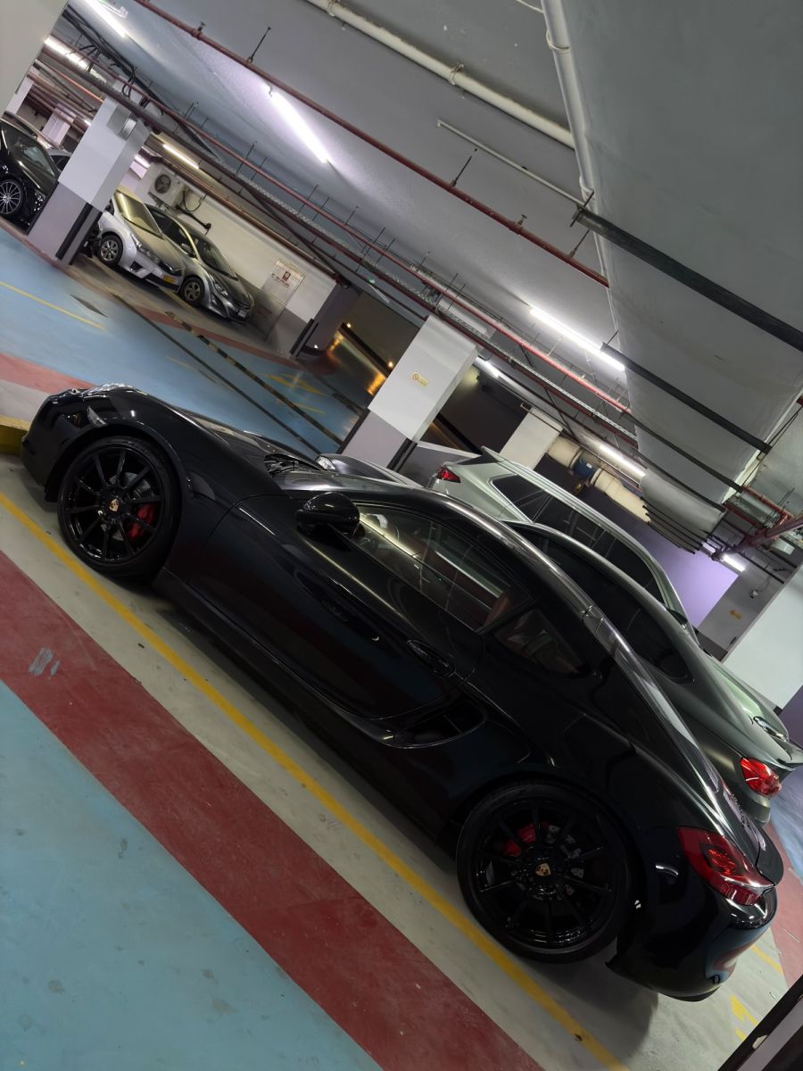 Porsche Cayman GTS black, side low angle